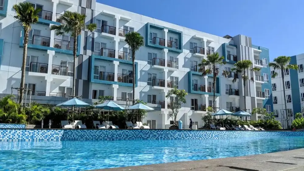 Pemandangan kolam renang hotel dengan latar kota Balikpapan